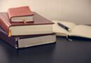 selective focus photography of three books beside opened notebook
