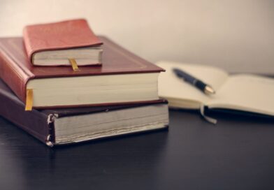 selective focus photography of three books beside opened notebook