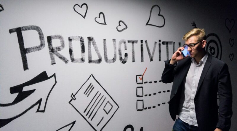 man holding smartphone looking at productivity wall decor