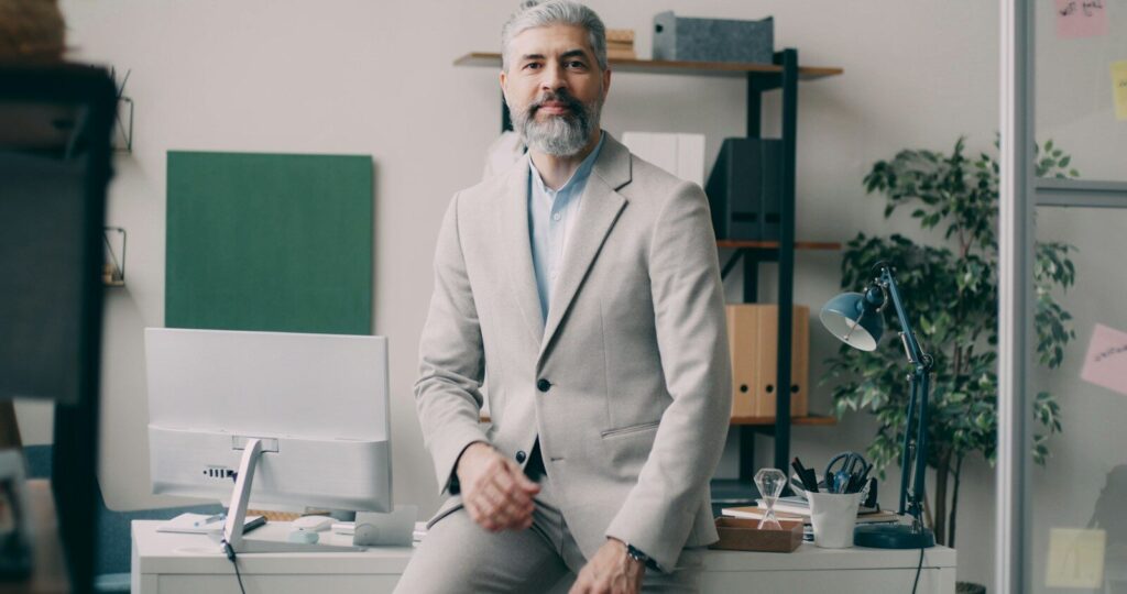 A man sitting on a desk in an office
