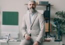 A man sitting on a desk in an office