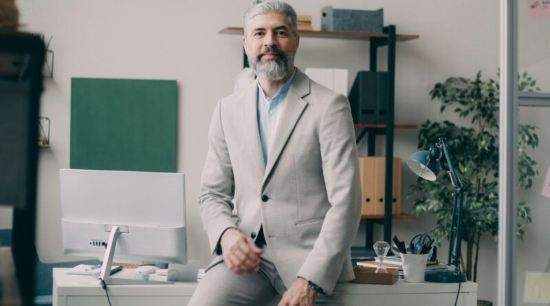 A man sitting on a desk in an office